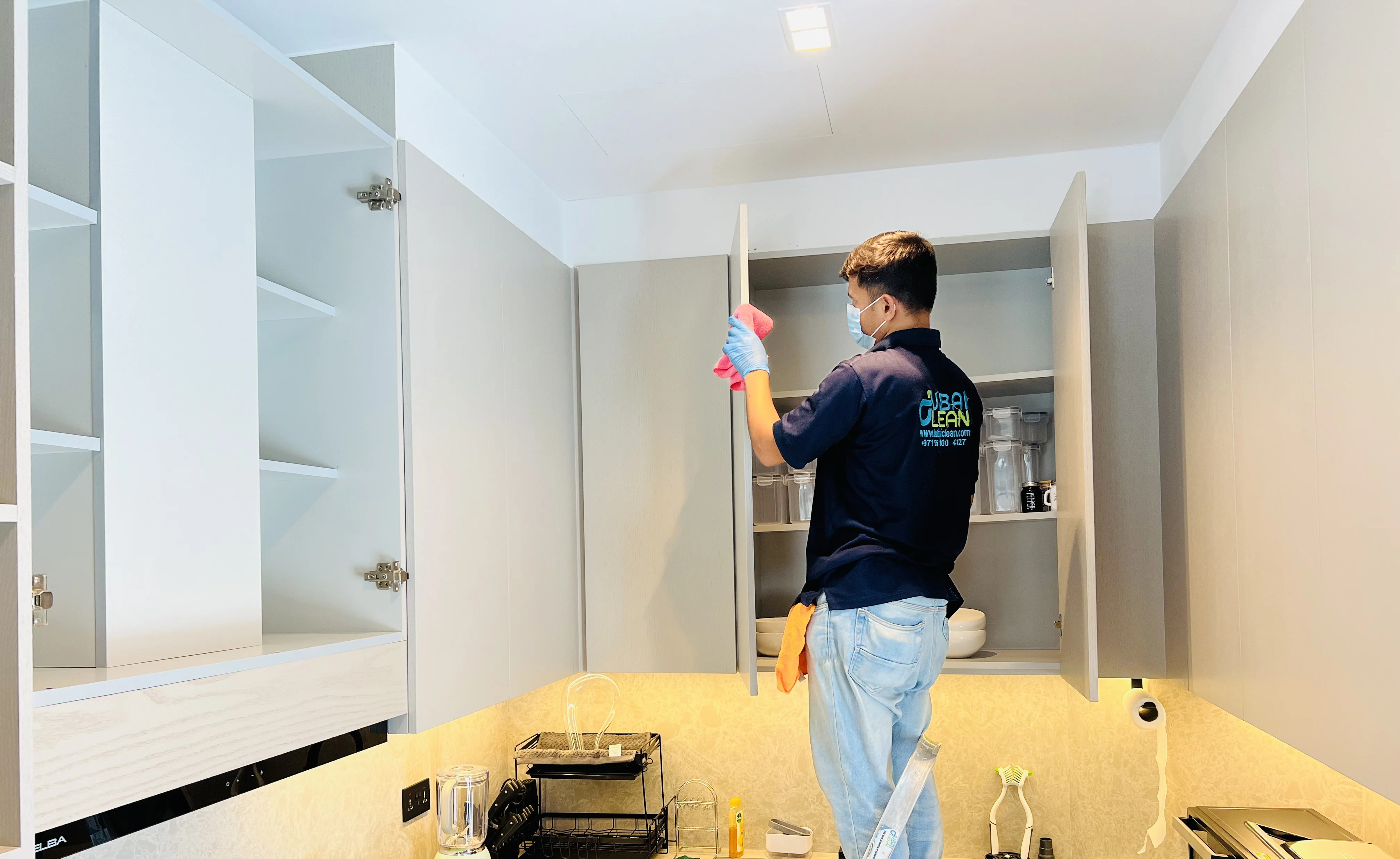 Professional cleaner carrying out residential cleaning in a fully furnished apartment using eco-friendly equipment.
