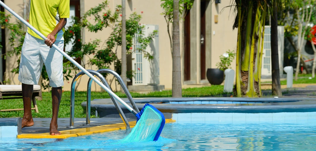 Professional swimming pool cleaning with vacuum, skimmer, and clear blue water