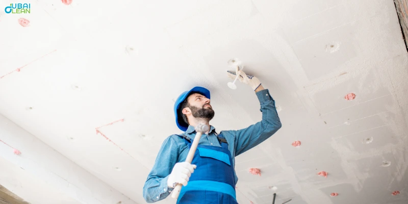 Technician performing false ceiling repair with professional tools